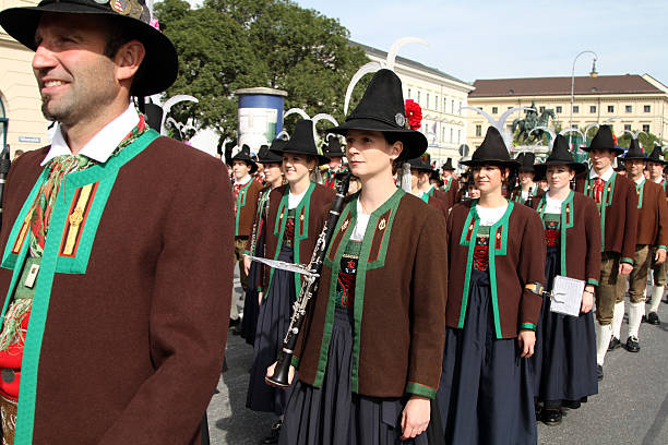 group Schützenkapelle Breitenbach am Inn, Austria oktoberfest grand parade Munich, Germany - September 22, 2013: Munich, Germany, September 22, 2013: The Schützenkompanie Breitenbach am Inn, Austria in the float of the grand parade. Men: leather trousers with green braces, red waistcoat, brown shooting jacket, circular hat with flowers and 2 cockerel feathers. Women: Traditional costume from the Unterinntal Region. Established in 1958. Leader: Josef Gruber. inn river stock pictures, royalty-free photos & images