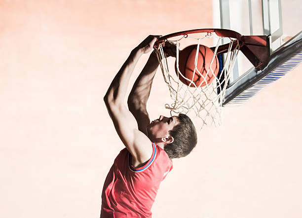 basketball spieler slam dunks. den ball. - basketball slam dunk basketball hoop sport stock-fotos und bilder