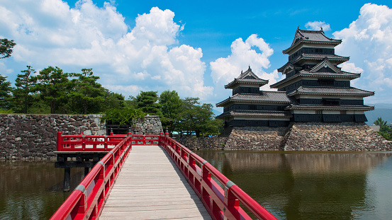 Matsumoto, Japan - July 27, 2012: The beautiful classic red bridge at the black Matsumoto castle the locally known as the crow castle, Nagano, Japan. 