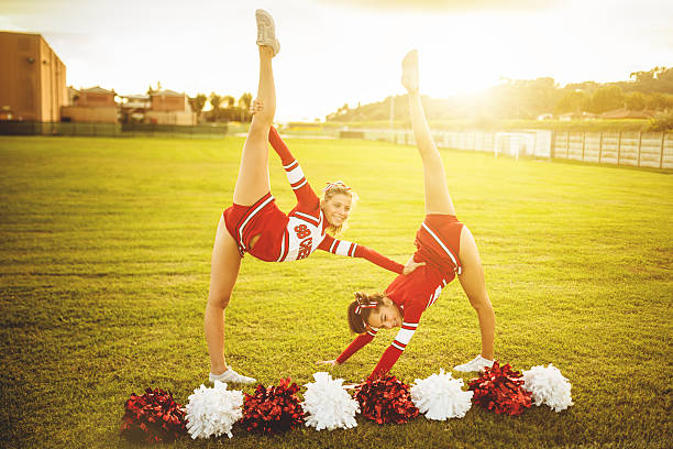 felicità cheerleaders in posa con pon-pon - cheering arms raised women university foto e immagini stock