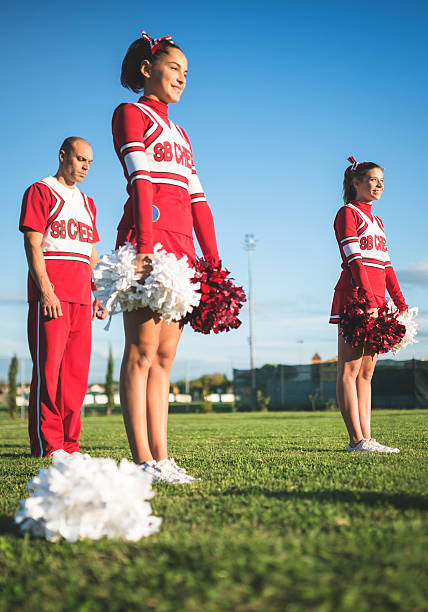 istock cheerleaders preparing to jump with the coach behind 472127161