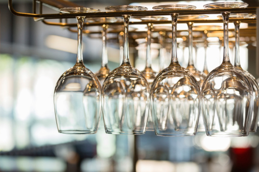 Wine glasses and stemware hanging above modern restaurant bar