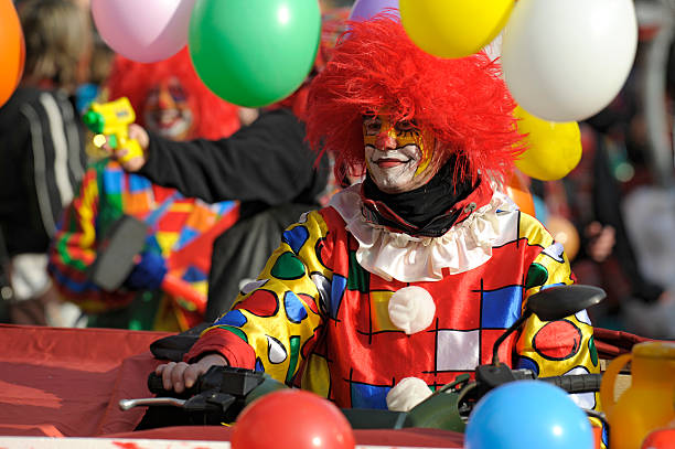 Clown at carnival parade Bad Hindelang, Germany - Februar 14, 2010: An unidentified clown with red hairs, self made clothes and colored ballons participates at the annual public carnival parade through the streets of city Bad Hindelang in southern part of Bavaria. mardi gras body painting stock pictures, royalty-free photos & images
