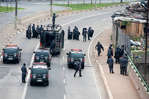 Riot squad São Paulo, Brazil, November, 01, 2013:Police riot squad in formation to hold a demonstration against the eviction of a slum in the north of the city of São Paulo in Brazil. Since June there has been constant demonstrations in major Brazilian cities by improvements in the infrastructure and policy transparency riot police stock pictures, royalty-free photos & images