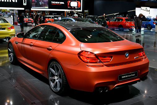 Brussels, Belgium - January 14, 2014: BMW M6 Gran Coupe saloon sports car on display at the 2014 Brussels motor show. People in the background are looking at the cars.