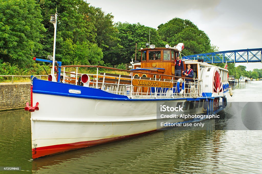 Leaving Teddington Lock London, United Kingdom - July 12, 2013: This is a view from a river cruiser leaving Teddington Lock on the River Thames at Teddington. On the prow of the boat is a tourist looking upriver to another paddle steamer approaching. Antique Stock Photo