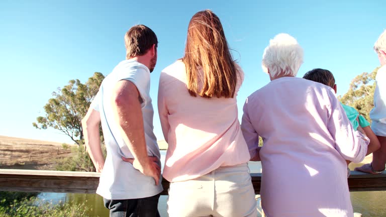 Rearview of a three generation family on a wooden jetty