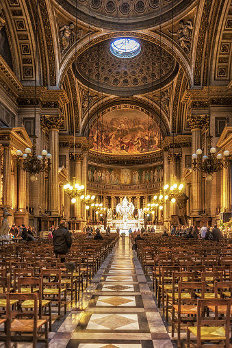 Paris, France - January 2, 2014: The Madeleine in Paris, France. Lot of tourists and pilgrims sitting and looking interiors
