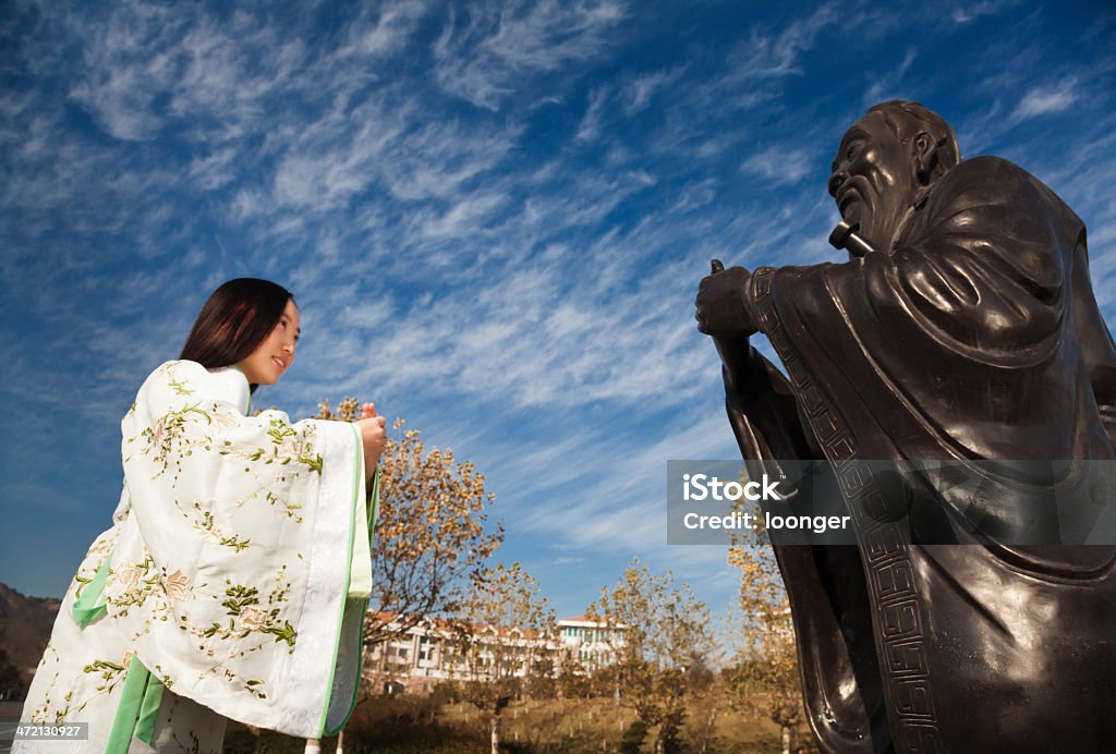 Girl bowed to Confucius East asian teenage girl bowed to Confucius under blue sky wihte clouds Confucius Stock Photo