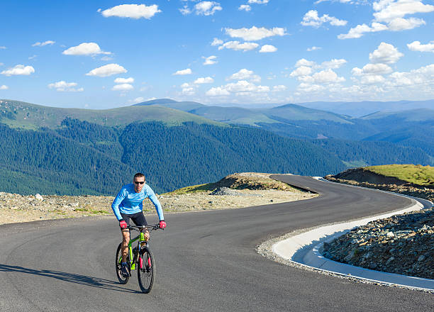 istock young man riding  bike on a mountain road 472131181