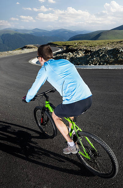 istock man on mountain bike going down the road 472131377