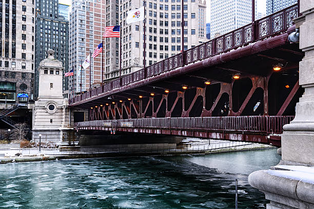 Michigan Avenue Bridge in Winter, downtown Chicago Chicago, USA - January 4, 2014: Michigan Avenue Bridge (DuSable Bridge) across the Chicago River, downtown Chicago in winter. Ice on river. Background people on bridge. editorial architecture famous place local landmark stock pictures, royalty-free photos & images