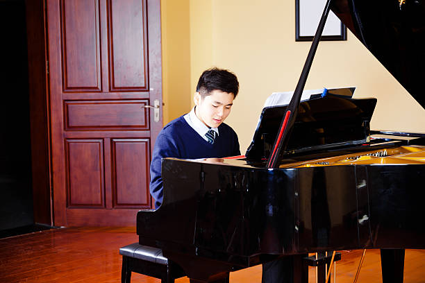istock teenager boy playing piano 472133333