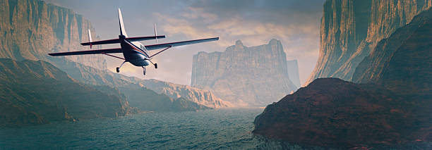 Small airplane flying over canyon river at sunset.