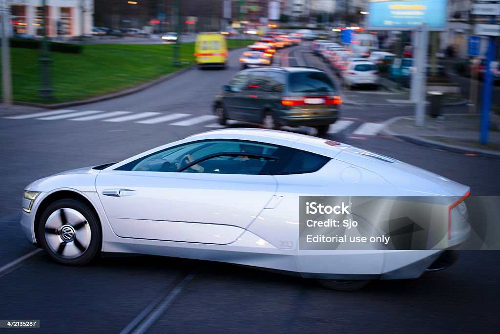 Volkswagen XL1 Brussels, Belgium - January 13, 2014: Volkswagen XL-1 driving on the streets of Brussel. The VW 1-litre car is a two-person concept car produced by Volkswagen. The 1-litre car was designed to be able to travel 100 km on 1 litre of diesel fuel. A man is sitting inside the car. Automobile Industry Stock Photo