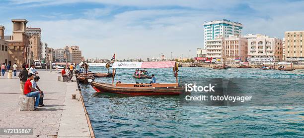 Dubai Creek People Relaxing Beside Busy Waterway Cityscape Panorama Uae Stock Photo - Download Image Now