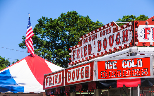 Falmouth, Massachusetts,USA-July 25, 2012: Colorful signage attracts customers to a fried dough stand at the Barnstable County Fair
