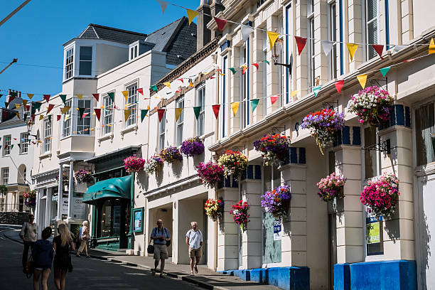 St. Peter Port, United Kingdom - July 10, 2013: Pedestrians on Smith Street, St. Peter Port, Guernsey. Decorated for summer, view upwards.