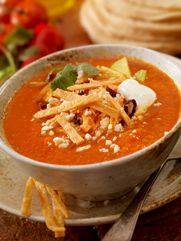 Authentic Mexican Tortilla Soup - Crispy tortilla stripes smothered in a chipotle tomato broth, garnished with chile pasilla, avocado slices, queso fresco (fresh cheese), sour cream, shredded chicken and radish slices. - Photographed on Hasselblad H3D2-39mb Camera