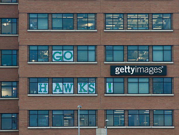 Seahawks Fans At Getty Images Seattle, United States - January 23, 2014: This image shows the exterior of the Getty Images building in Seattle, Washington where Seattle Seahawks fans have put up signs in the window spelling out Go Hawks! The Seahawks football team are playing in the Superbowl and fans in Seattle and the Northwest are very excited. getty image stock pictures, royalty-free photos & images