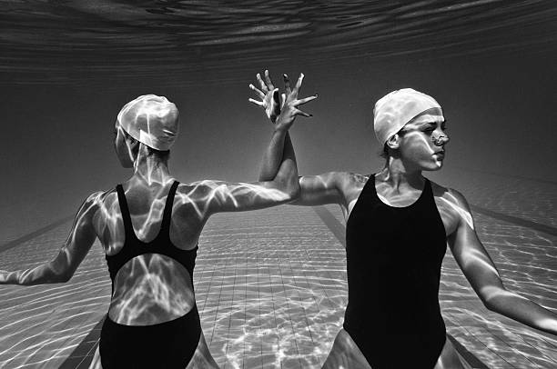 Underwater performing act Synchronized swimmers performing underwater immersed in their work stock pictures, royalty-free photos & images