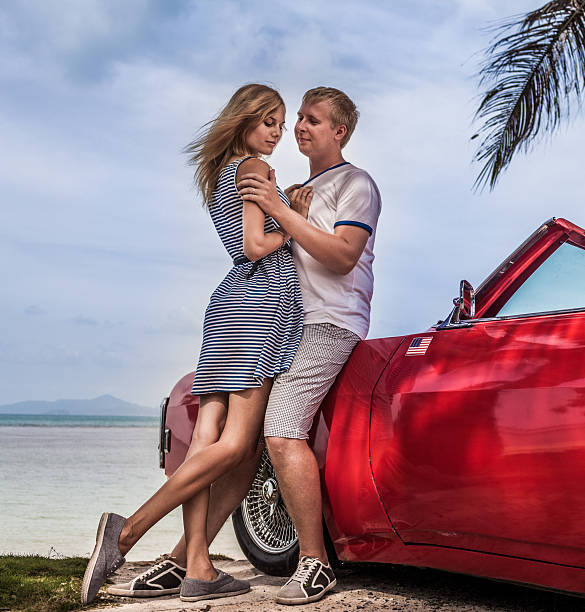 istock Young happy couple with old style car 472138329