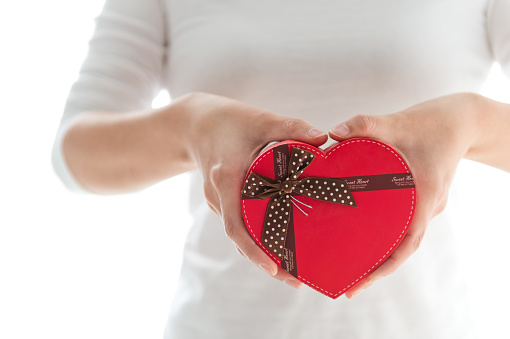 Woman holding a heart shape gift box.