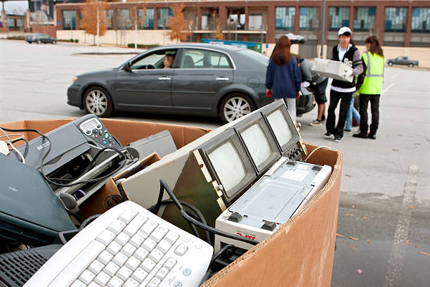 People Drop Off Electronics At Recycling Event Lawrenceville, GA, USA - November 23, 2013:  Volunteers help carry electronic items being dropped off at Gwinnett County's America Recycles Day event. recycling computer electrical equipment obsolete stock pictures, royalty-free photos & images