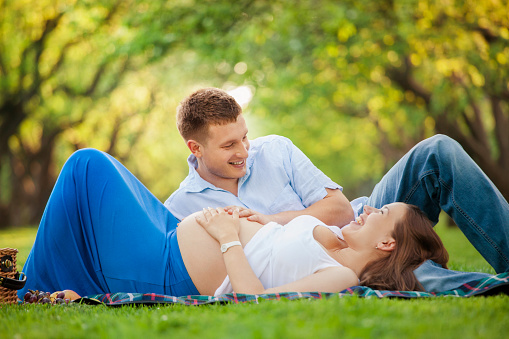 Pregnant woman with her husband relaxing in a park