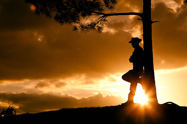 cowboy: silueta ganadero, agricultor tiene campo después de rainstorm al atardecer. - cowboy hat hat wild west black fotografías e imágenes de stock