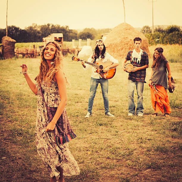 istock Hippie group singing and dancing in a field 472141787