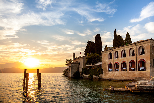 Lake Garda, Italy - July 19, 2012: Sunset at Punta San Vigilio with the Locanda  San Vigilio - Hotel and Restaurant.