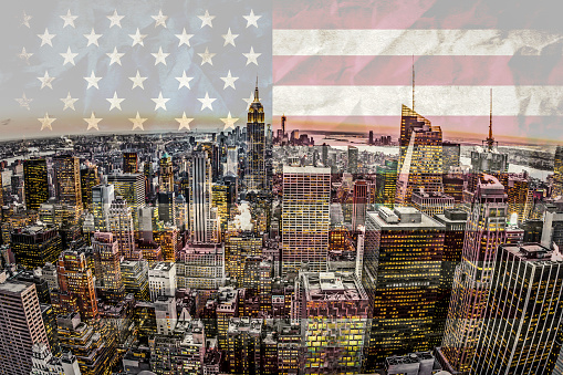 New York skyline at sunset with American flag background.