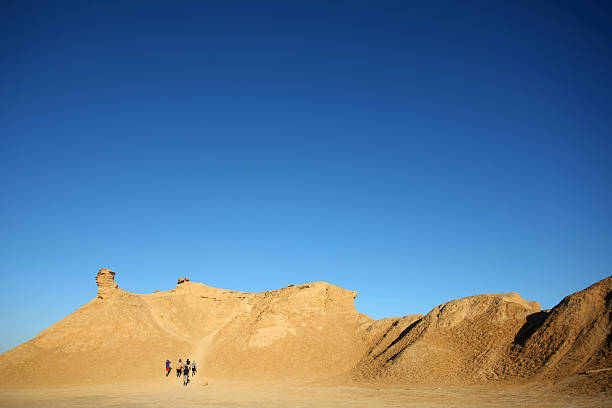 Ong Jemel, Tozeur,Tunisia - September 16th, 2012: Tourists climb on the top of camel head rock, one of the tourist stops in Ong Jemel, Tozeur,Tunisia. Ong Jemel is the place near Tozeur, where the movies Star wars and the English Patient were filmed.