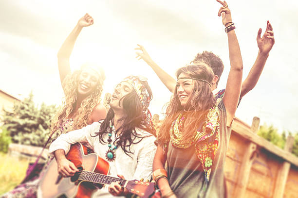 hippy grupo tocando la guitarra y bailar juntos - 1970s style women hippie retro revival fotografías e imágenes de stock