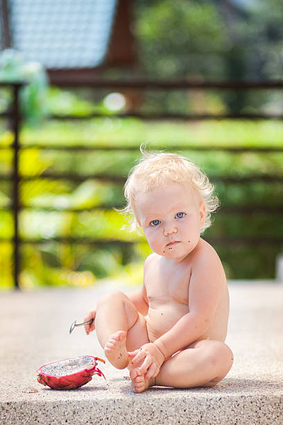istock Baby girl eating dragon fruit 472144864
