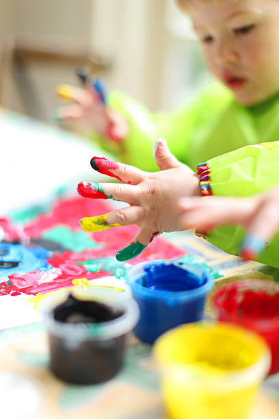 istock Child Painting with Colorful Fingerpaint 472144976