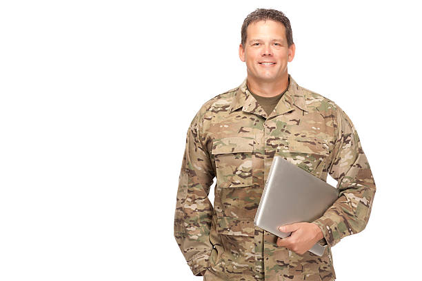 istock U.S. Army Soldier, Sergeant. Isolated and holding computer lapto 472145058