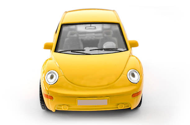 London, England, January 26, 2014: A yellow Volkswagen Beetle toy car seen from the front. This photo was taken in a studio in front of a white background