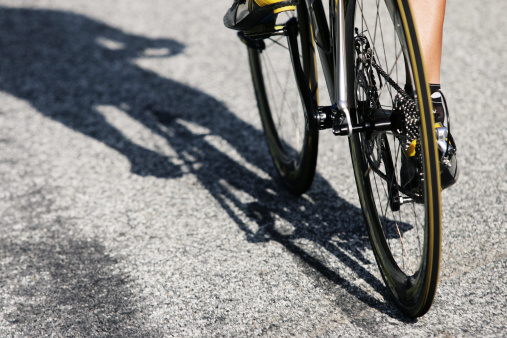 A close up view of a male professional road cyclist and his racing bicycle.