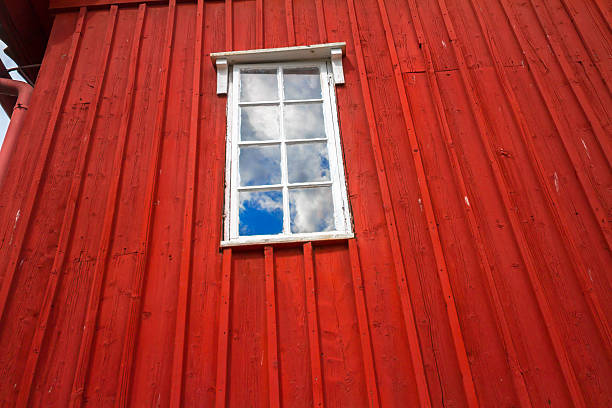 istock Red wooden wall and a window with clouds reflected 472147614