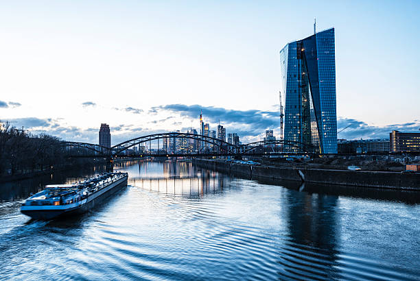 European central Bank, ECB, EZB,Frankfurt Skyline, Germany, View at the European Central Bank at dusk. In the bach the skyline with the financial district of rtankfurt. Blue toned Some noise. January 2014 panoramic riverbank architecture construction site stock pictures, royalty-free photos & images