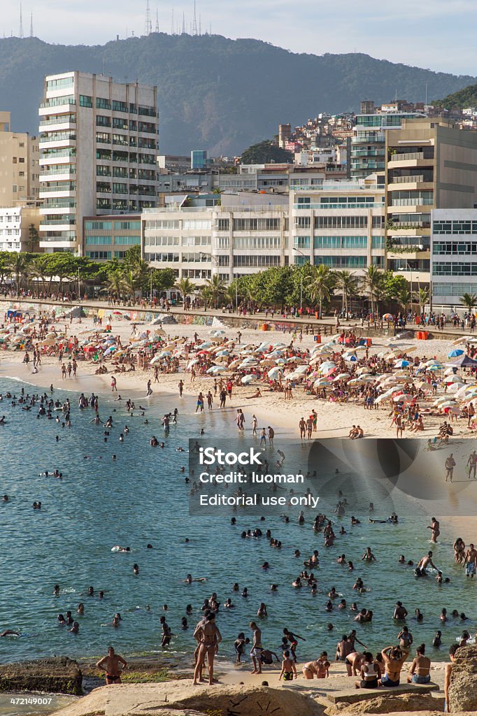 Arpoador Beach Rio de Janeiro, Brazil - January 2, 2014: Thousands of sunbathers relax in Arpoador Beach and Stone in a beautiful and hot summer afternoon. Arpoador Beach Stock Photo