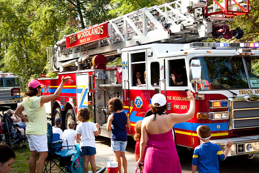 The Woodlands, Texas, USA - July 4, 2011: Fire trucks in a July 4th parade in The Woodlands, Texas, USA. Many families wave at the firefighters as they pass by in their trucks on the parade route.  This parade is held every year in The Woodlands to celebrate America's birthday, which was on July 4, 1776.