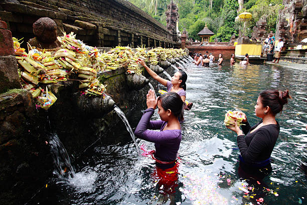 Bali, Indonesia - May 6, 2013: Worshippers make an offering at the Tirta Empul Temple in Bali, Indonesia. 