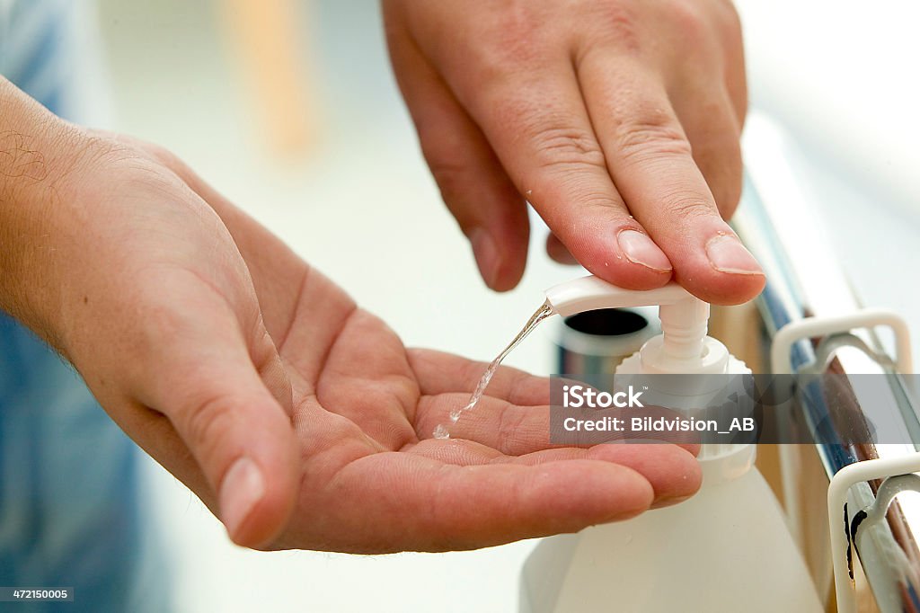 Close up of hands squirting disinfectant from a pump bottle Desinfecting hands in a hospital.JH Hygiene Stock Photo