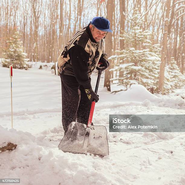 Old Man Cleaning Doorway Before House From Snow After Snowfall Stock Photo - Download Image Now
