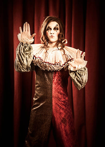 Puzzled man in striped sweater, white gloves with perplex face. Clown, artist , mime. Studio shot, pink background