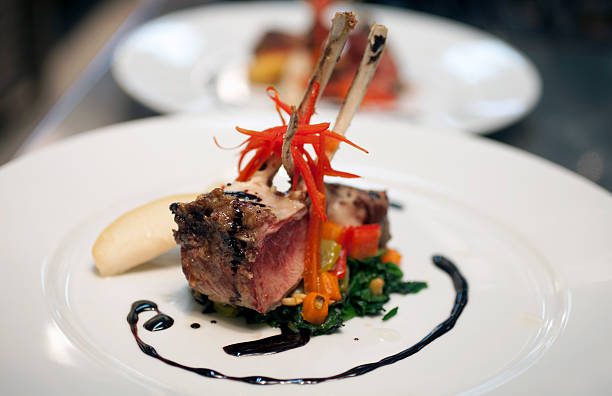 istock One lamb chop placed on veggies with a swirl of dark liquid  472152199