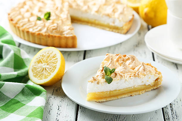 istock Lemon meringue pie on plate on white wooden background 472152874
